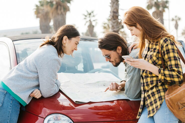 Cheerful Women With Smartphone Near Man Looking Map Car Hood 23 2148039113 1